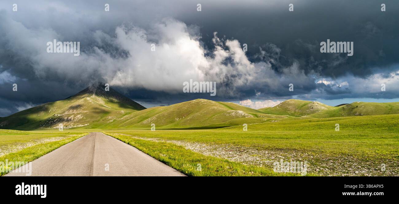 A scenic view of a winding road leading through lush green hills under ...