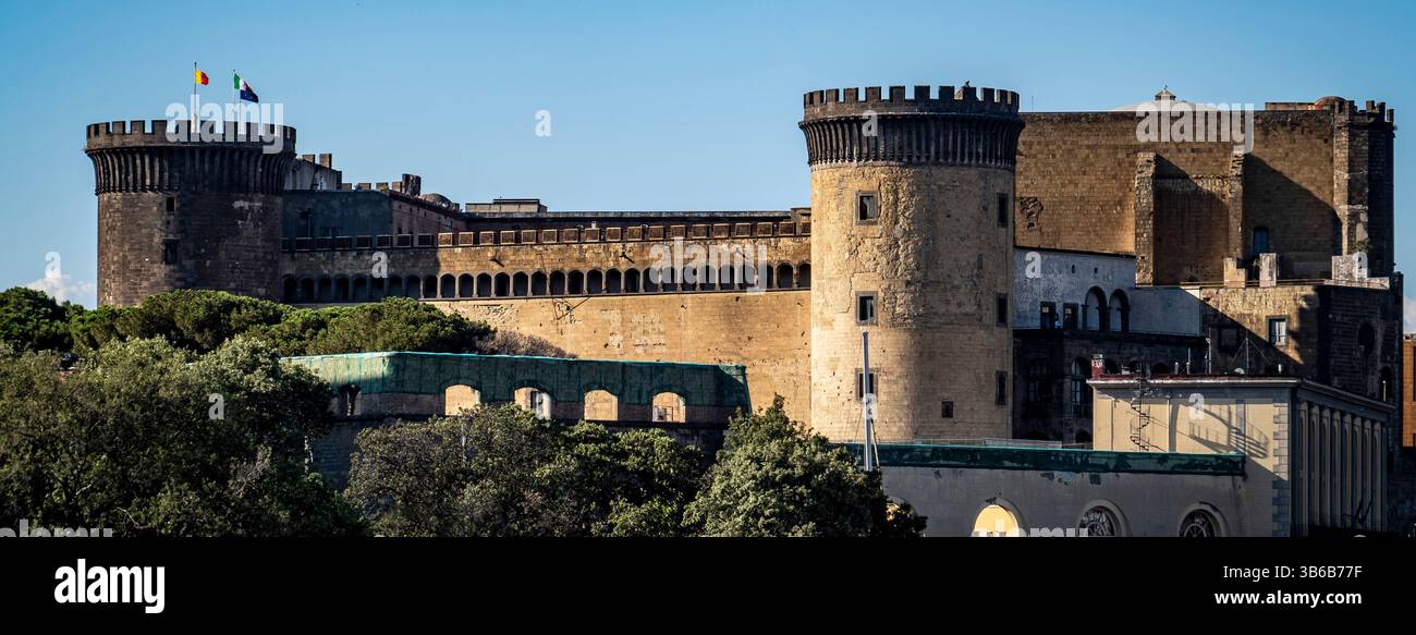 A historic castle with stone walls and towers, surrounded by greenery ...