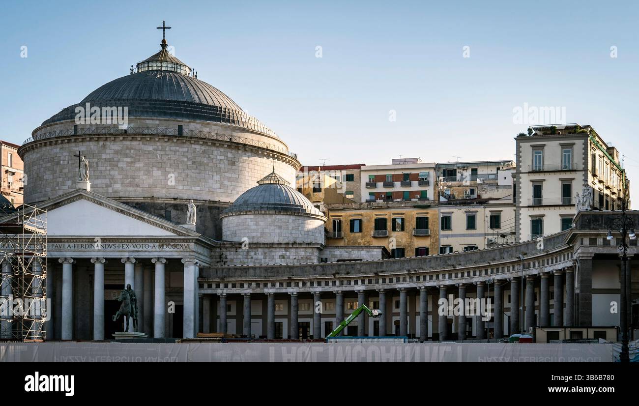 A historic building with a large dome and colonnade, set against a clear sky. The architecture features classical elements, with surrounding urban str Stock Photo