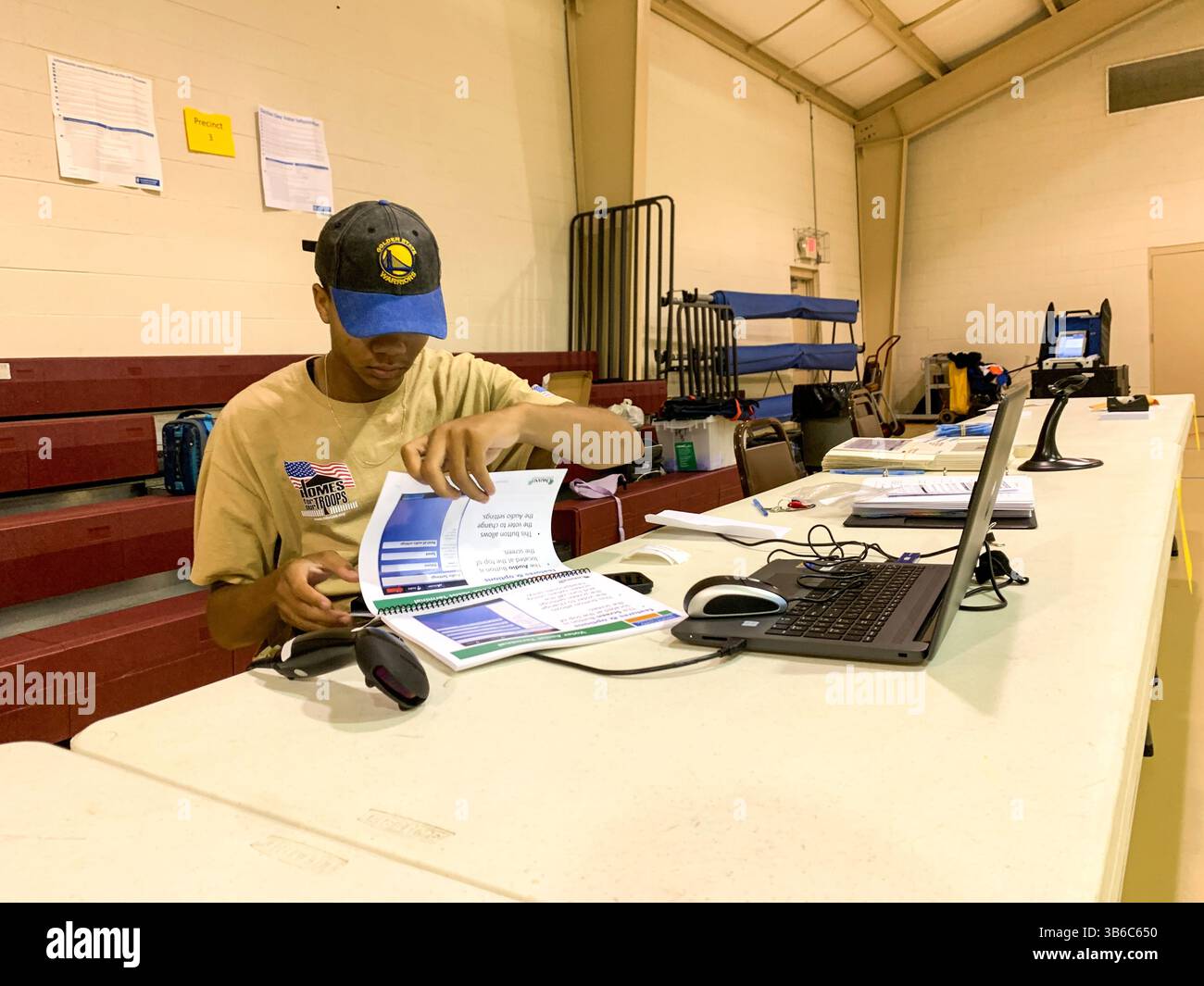 July 19, 2022, Pontiac, Michigan, USA: Josiah Elam reviews the instruction manual for poll workers, who are called Election Inspectors in Michigan. He is almost 18 years old and has been working the polls since he was 16. (Credit Image: © Sue Dorfman/ZUMA Press Wire) Stock Photo