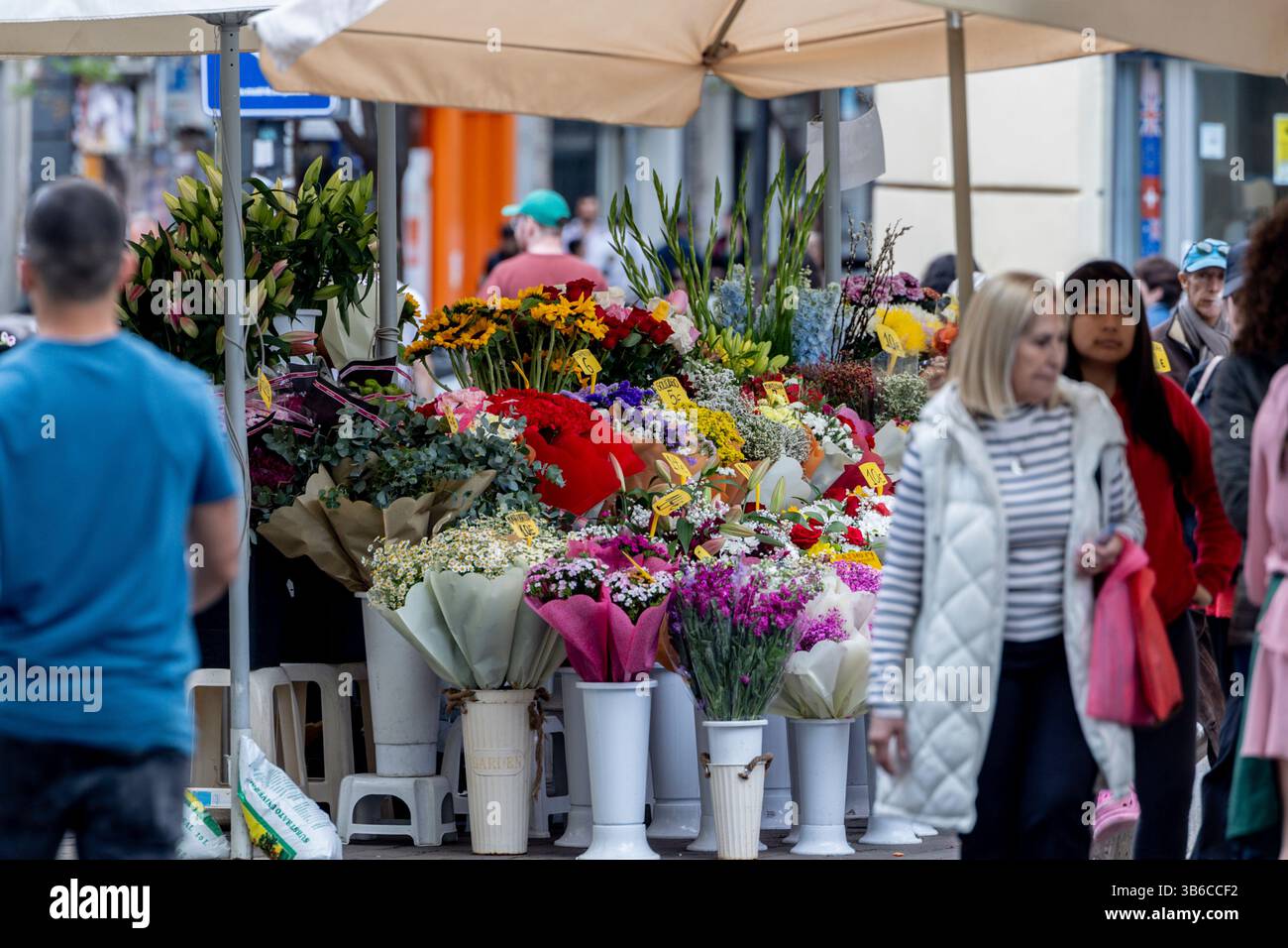 Several People At A Stall In The Tirso De Molina Flower Market On May 3 several-people-at-a-stall-in-the-tirso-de-molina-flower-market-on-may-3