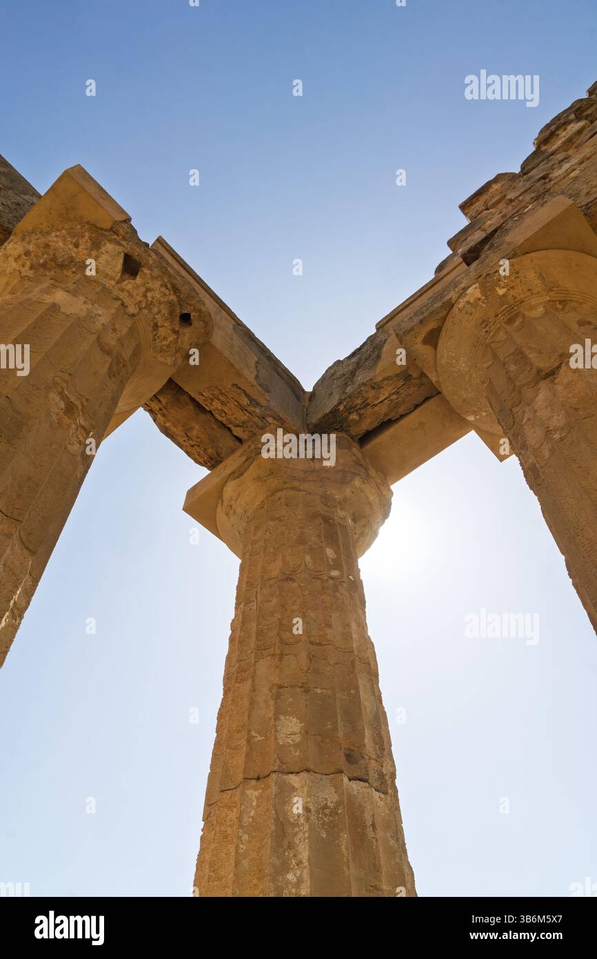 Sun shining behind doric order columns of an ancient greek temple in ...