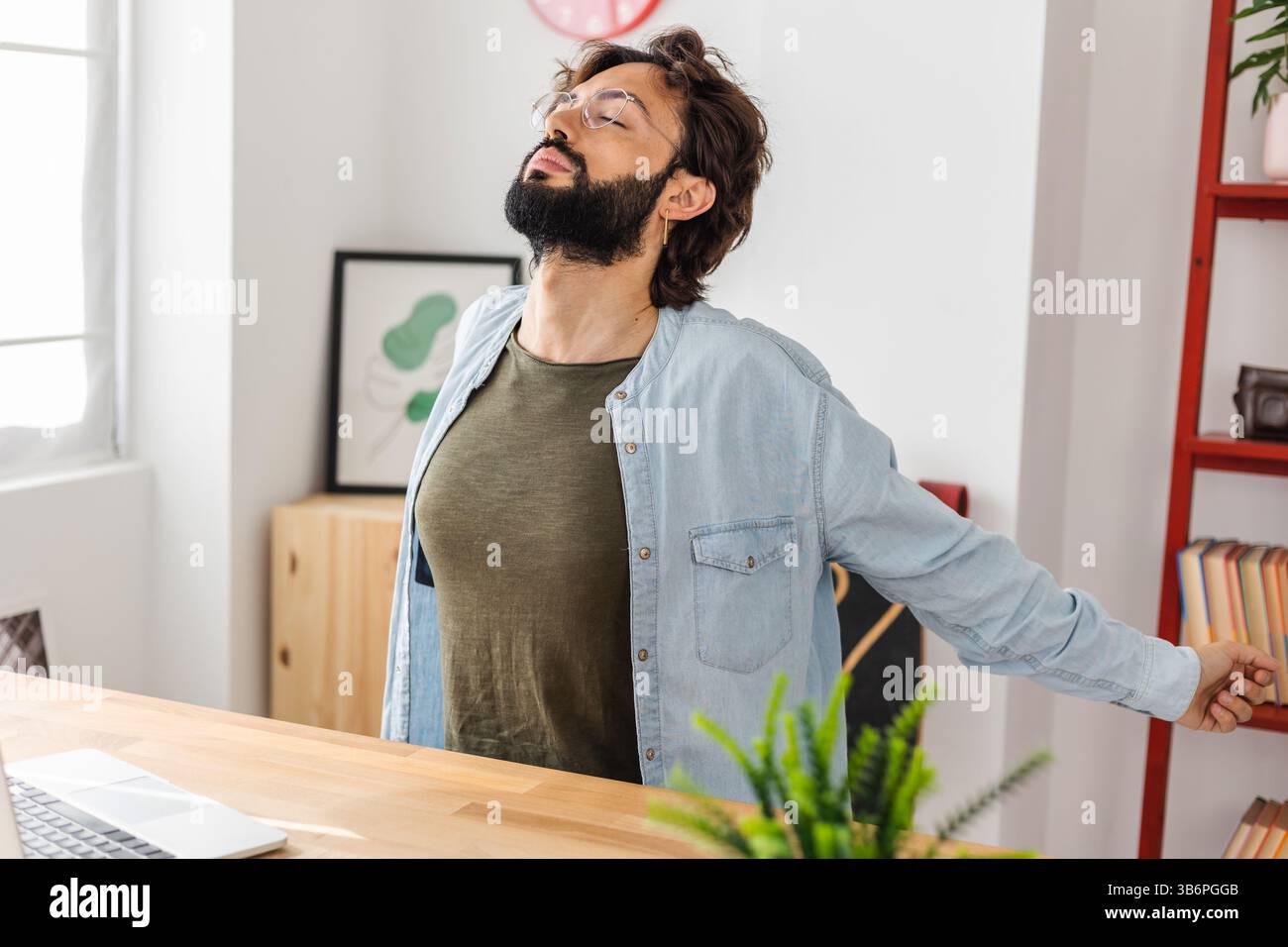 Hipster young man doing a stretching exercise while taking a break from work Stock Photo