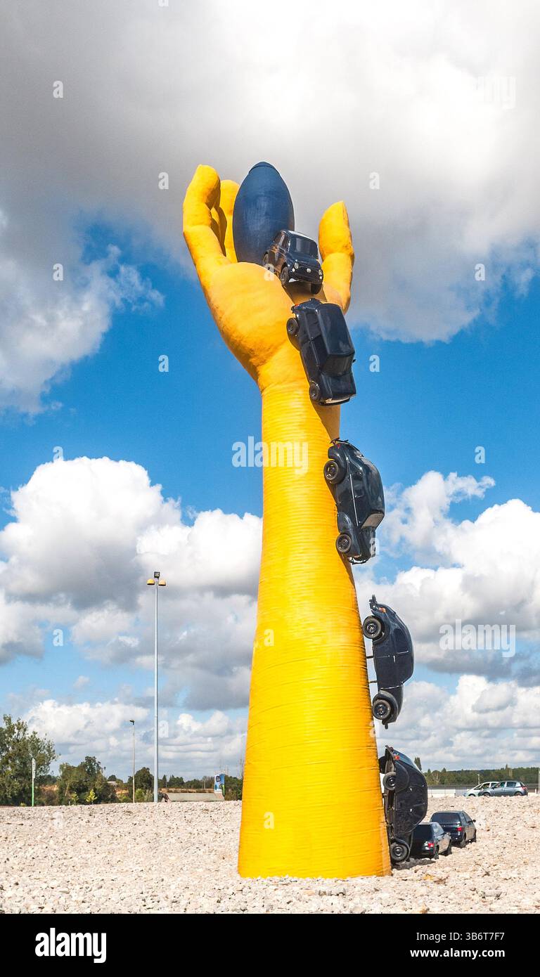 "La Main Jaune" (The Yellow Hand) a 24m tall sculpture of an arm and several cars (now destroyed) created by Dr Francis Guyot - Chatellerault, France. Stock Photo