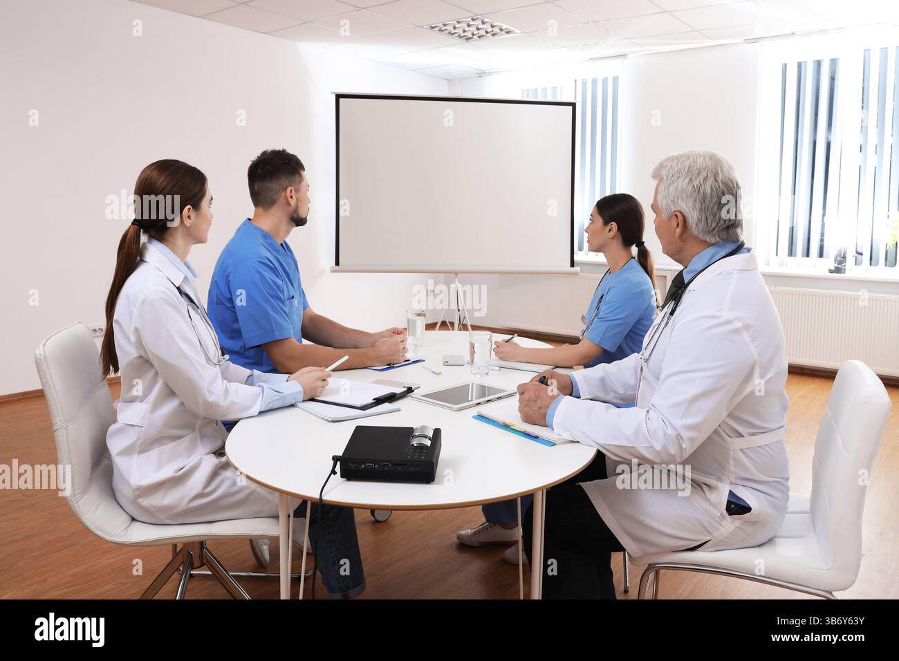 Team of doctors using video projector during conference indoors Stock Photo