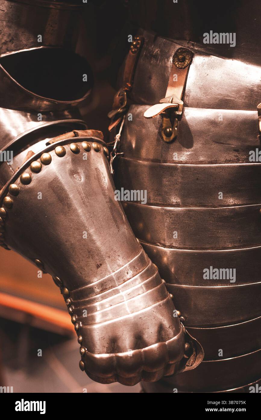 Shiny metal suit of armor with articulated plates and buckles. Stock Photo