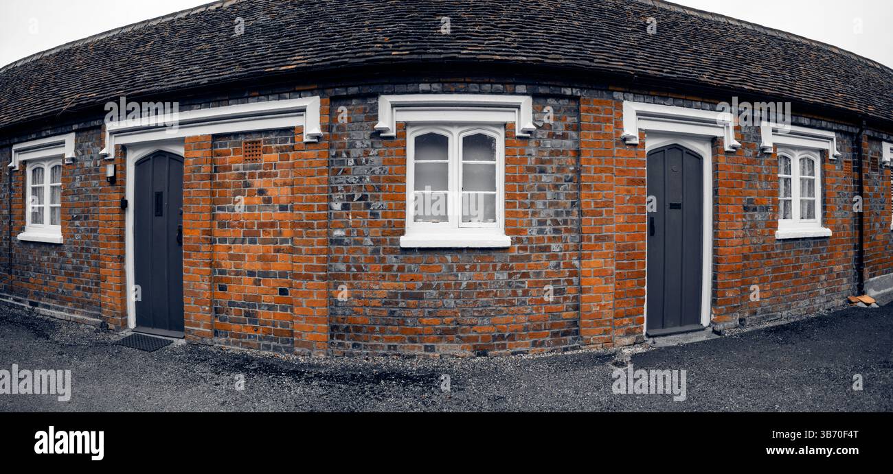 Curved brick cottage facade with two doors. Stock Photo