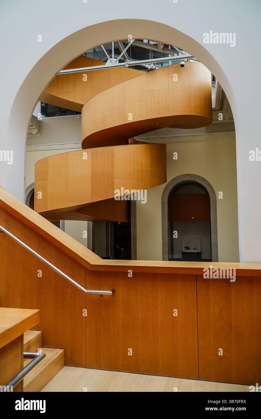 Modern wooden spiral staircase inside a large building. Architectural ...