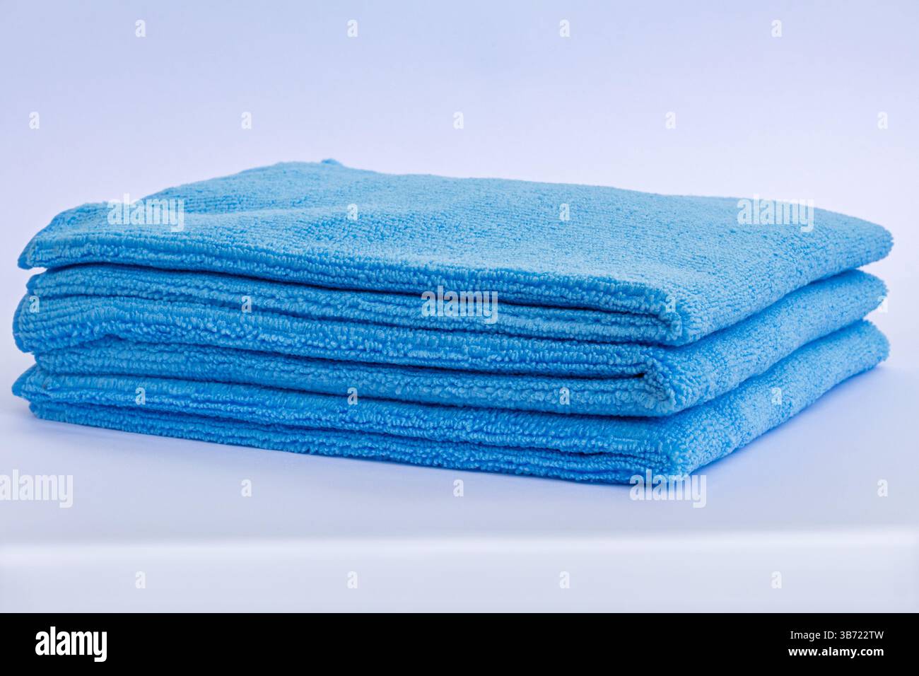 Three blue low pile height microfiber towels stack isolated on white background Stock Photo