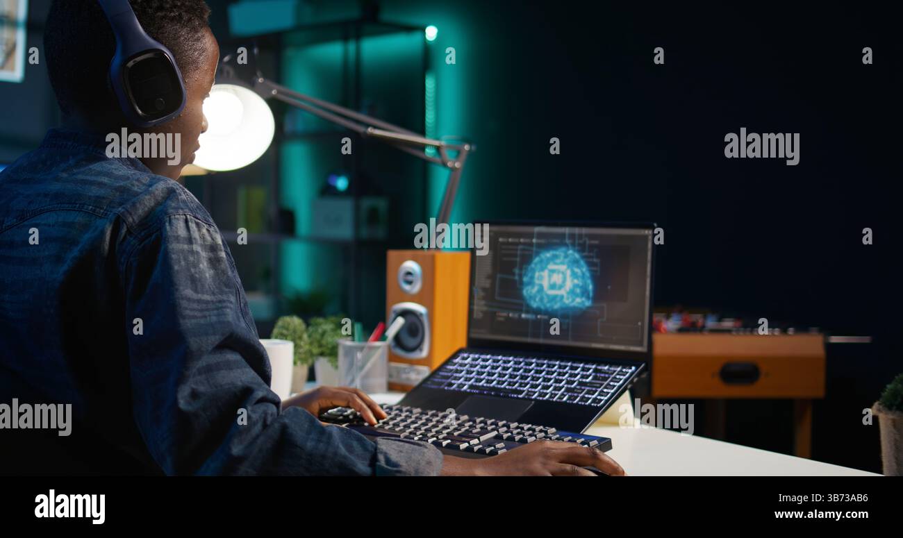 Data scientist using laptop, updating artificial intelligence machine learning algorithms, writing code scripts. Teleworking IT specialist in apartment office uses programming to upgrade AI, camera B Stock Photo