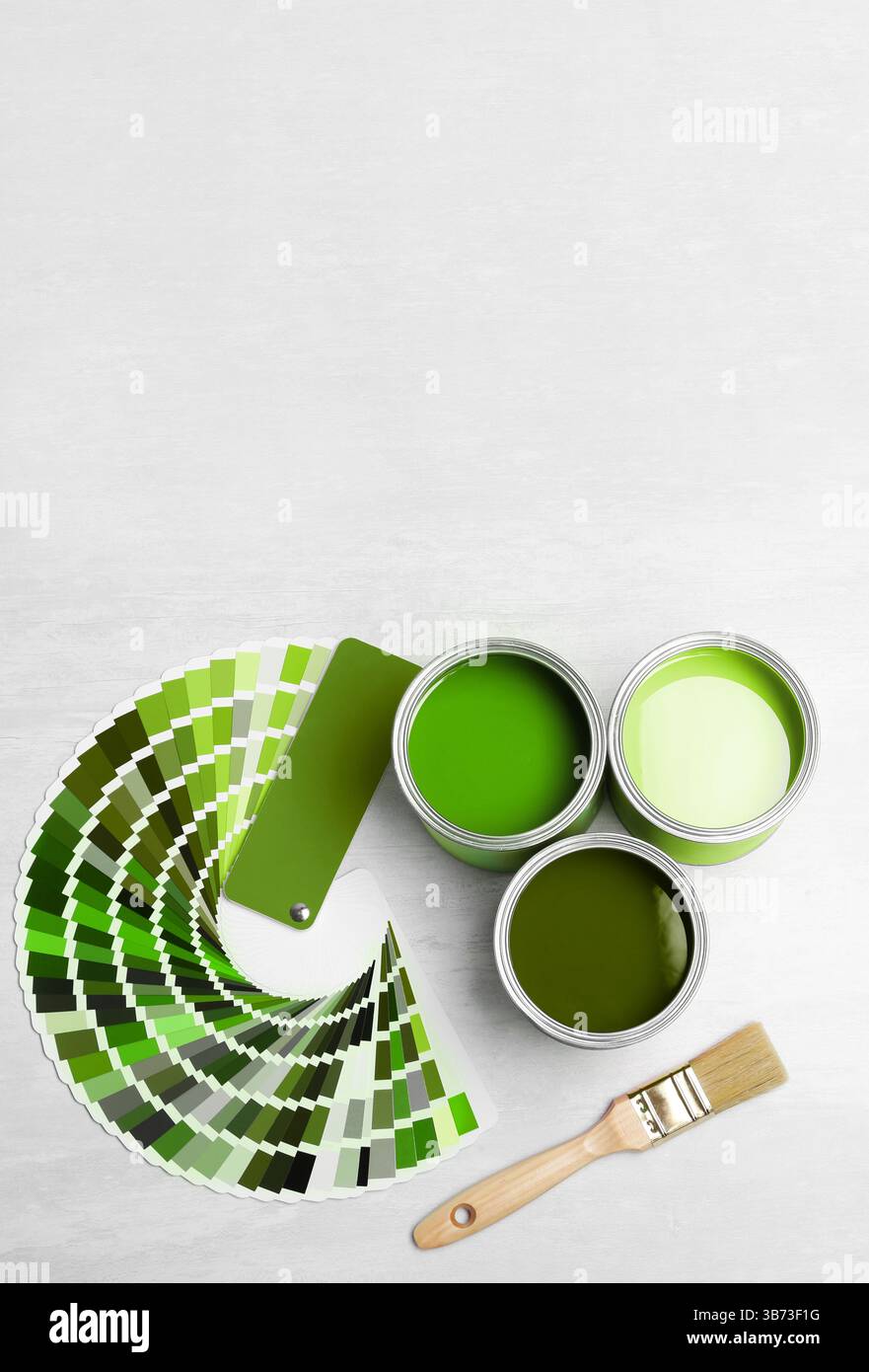 Cans with paint in shades of green, brush and color palette on white ...