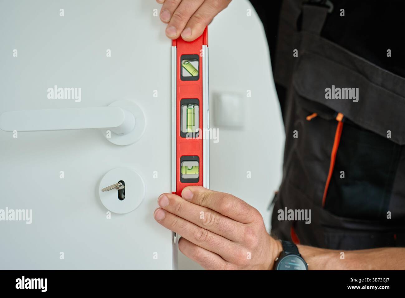 Interior Alignment Professional handyman using spirit level to check vertical alignment of ...