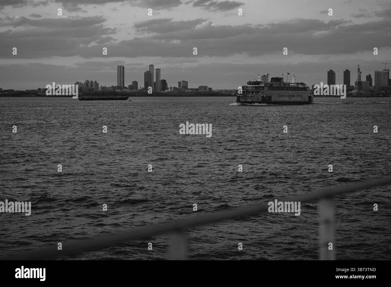 A black and white photo of a ferry with a city skyline Stock Photo - Alamy