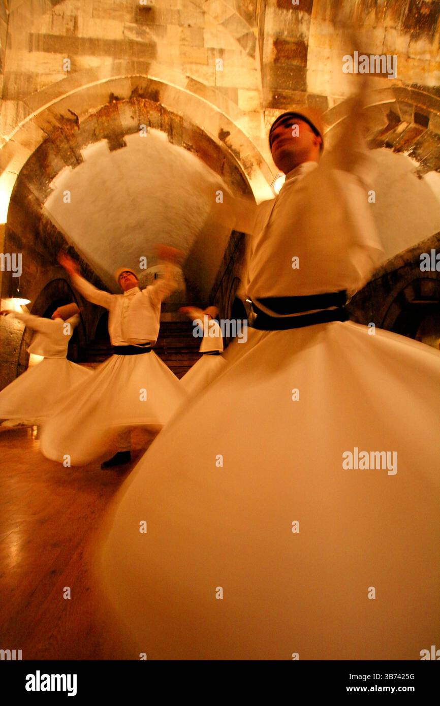 Whirling Dervishes: Men twirl in long whit robes as a part of a traditional Turkish Sema (ceremony). Stock Photo