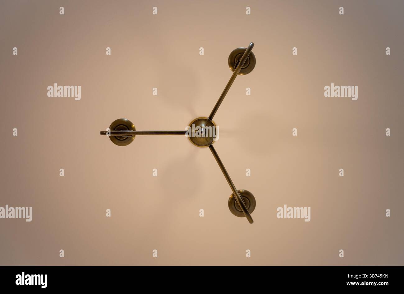 Chandelier style electric light fitting on a ceiling seen directly from below Stock Photo