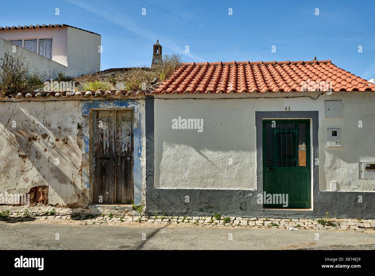 Derelict and renovated traditional houses side by side in Cabanas de Tavira, Algarve, Portugal. Stock Photo