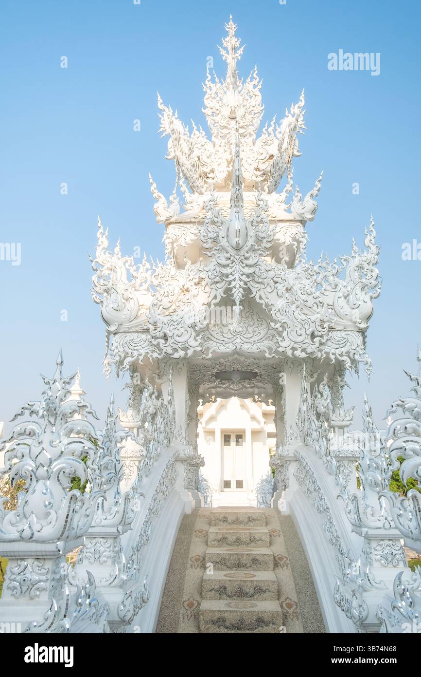 White ornate bridge leading to one of the buildings at White temple ...