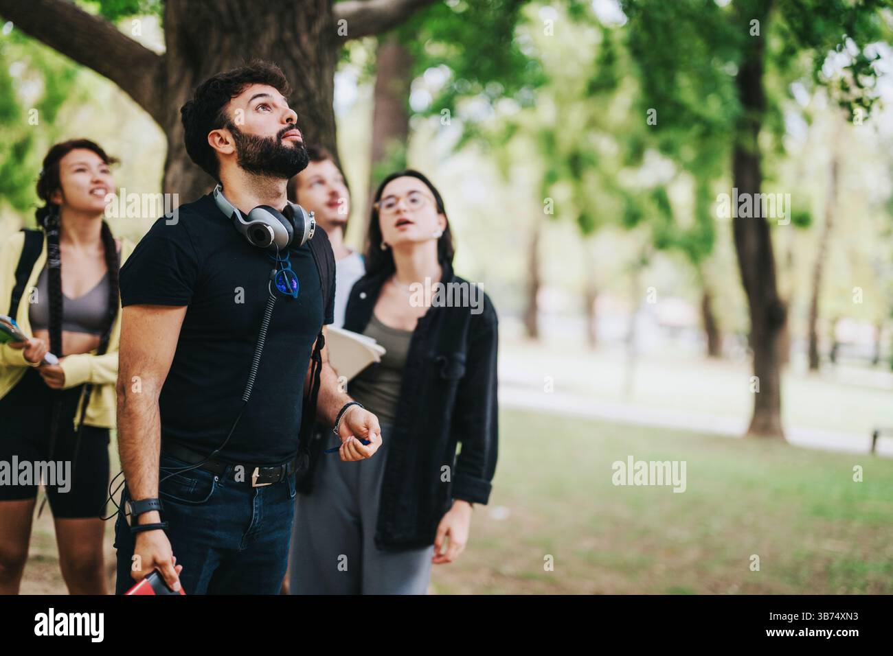 Young multicultural students collaborating on a school project in the park Stock Photo