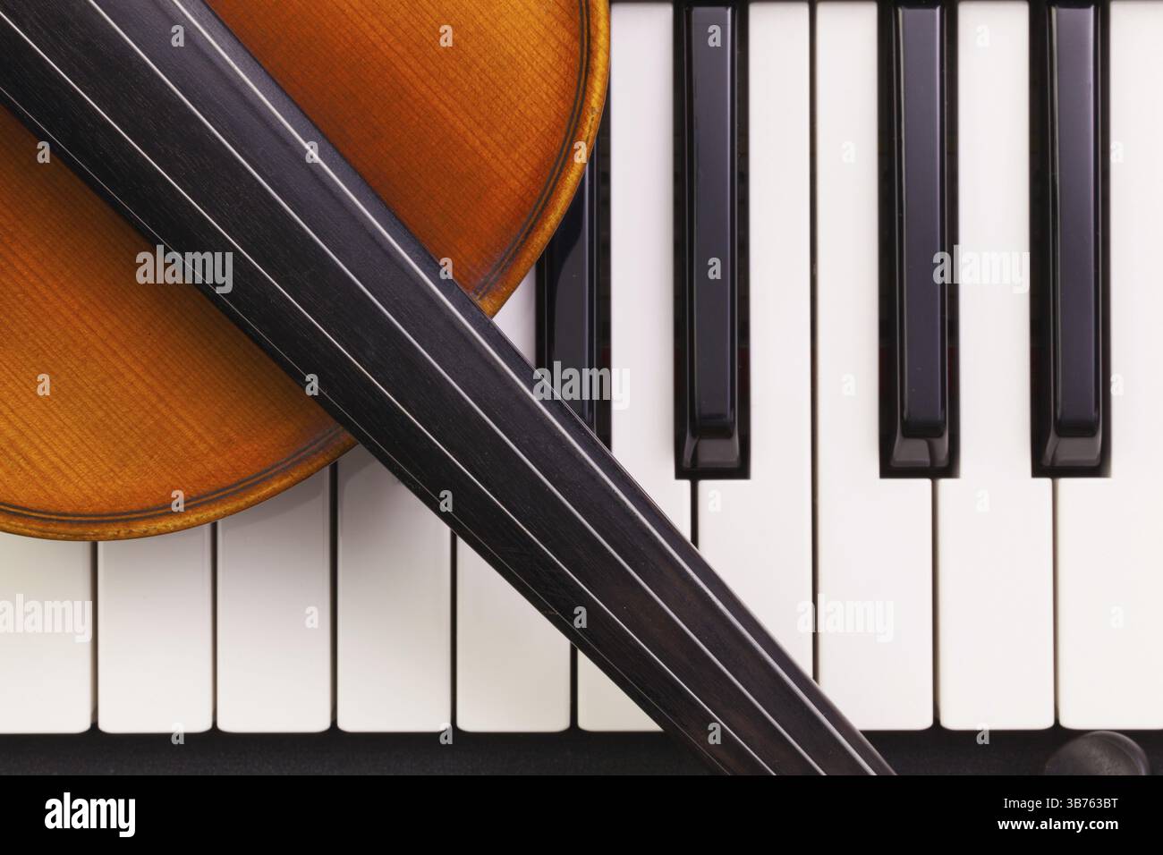 Very old violin lying on the piano Stock Photo