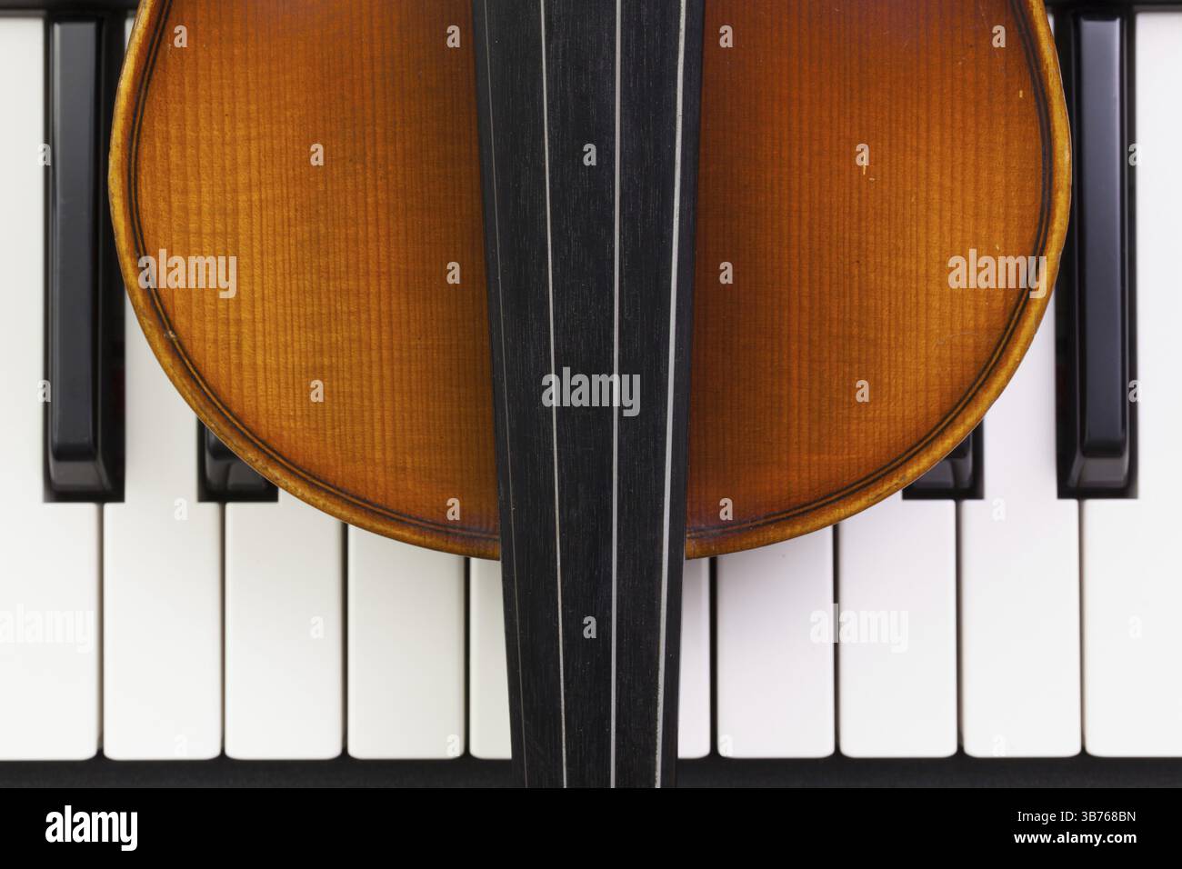 Very old violin lying on the piano Stock Photo