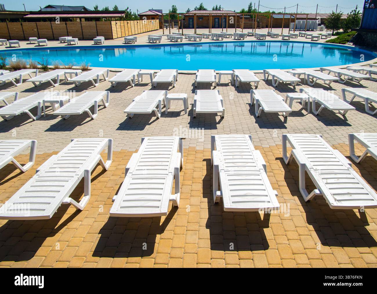 Russian Pool Model Voronezh, Russia - April 30, 2024: Empty sun loungers in front of the ...