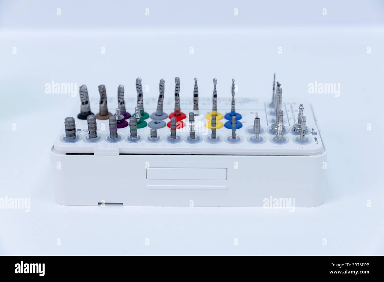A meticulously arranged collection of drill bits and precision tools displayed on a white tray, designed for various applications including engineerin Stock Photo