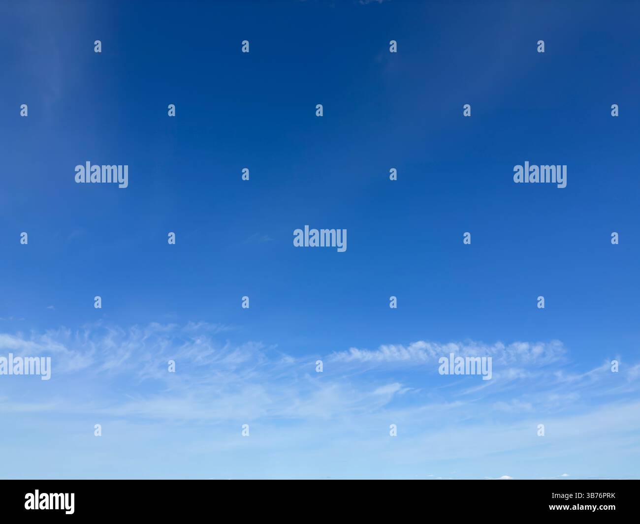 Vibrant blue sky with soft white clouds, creating a tranquil and beautiful scene. - Smartphone Captured Stock Image