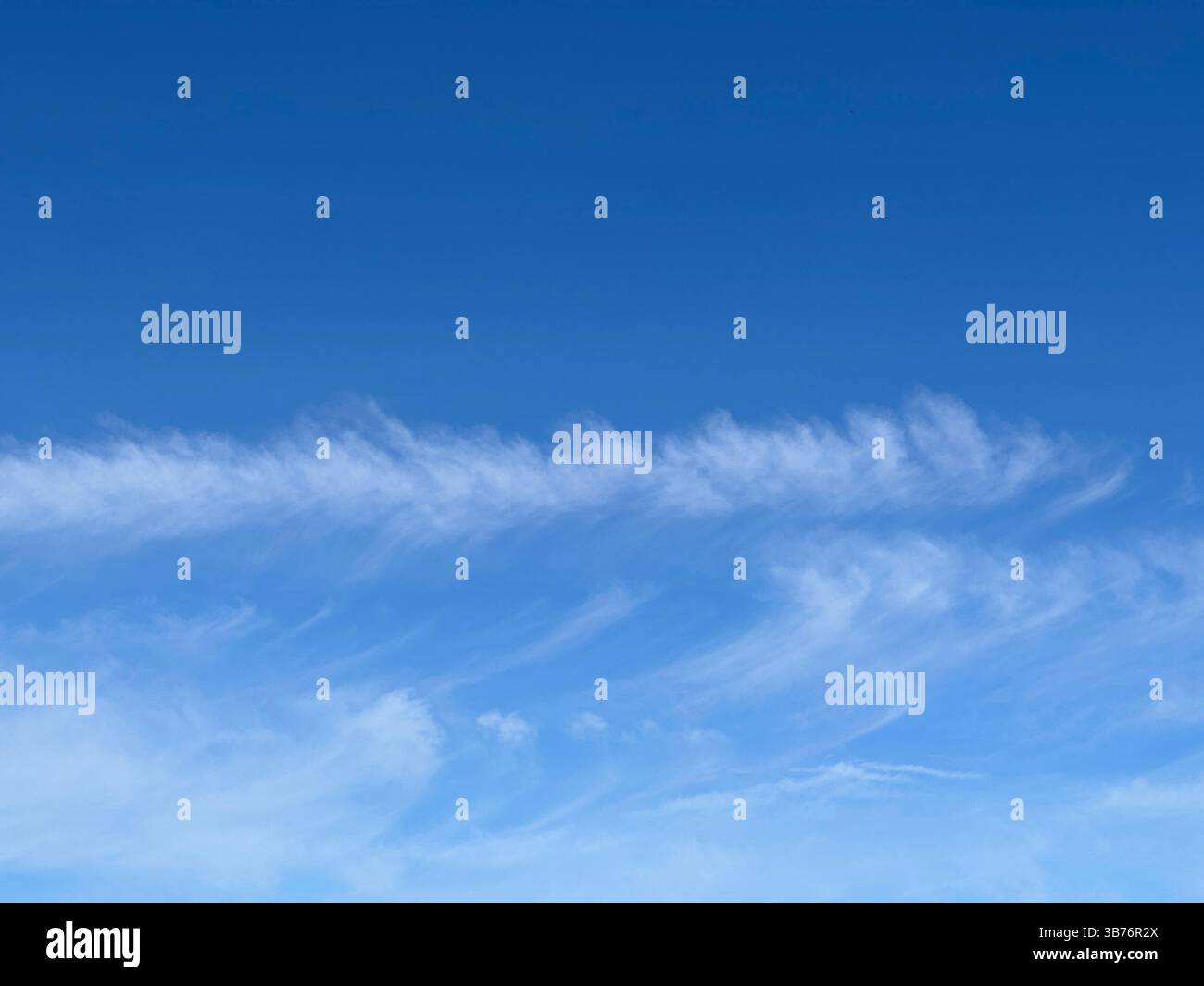 Vibrant blue sky with soft white clouds, creating a tranquil and beautiful scene. - Smartphone Captured Stock Image