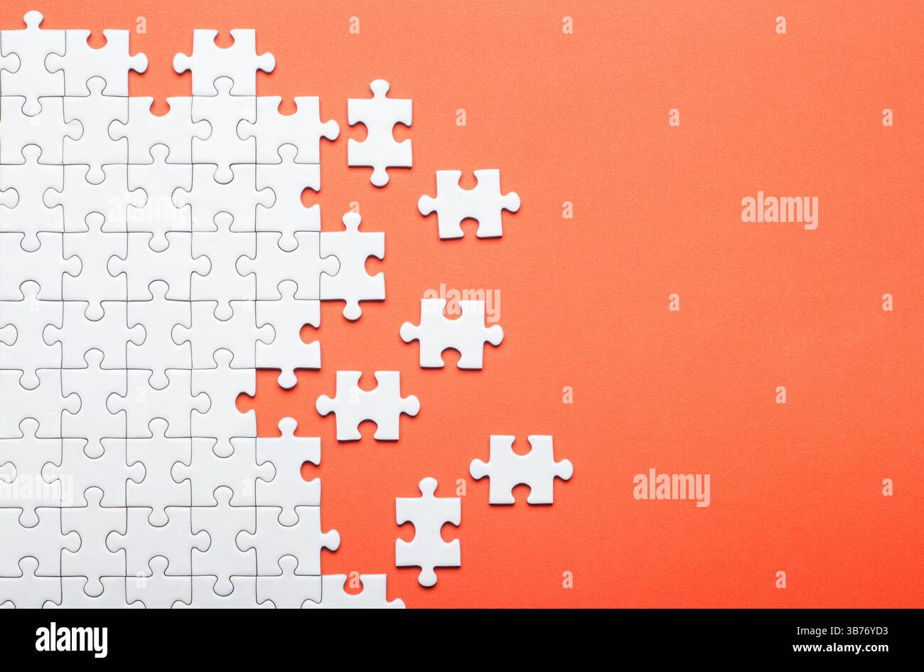 White Puzzle Pieces on Orange Background Representing Problem Solving Stock Photo