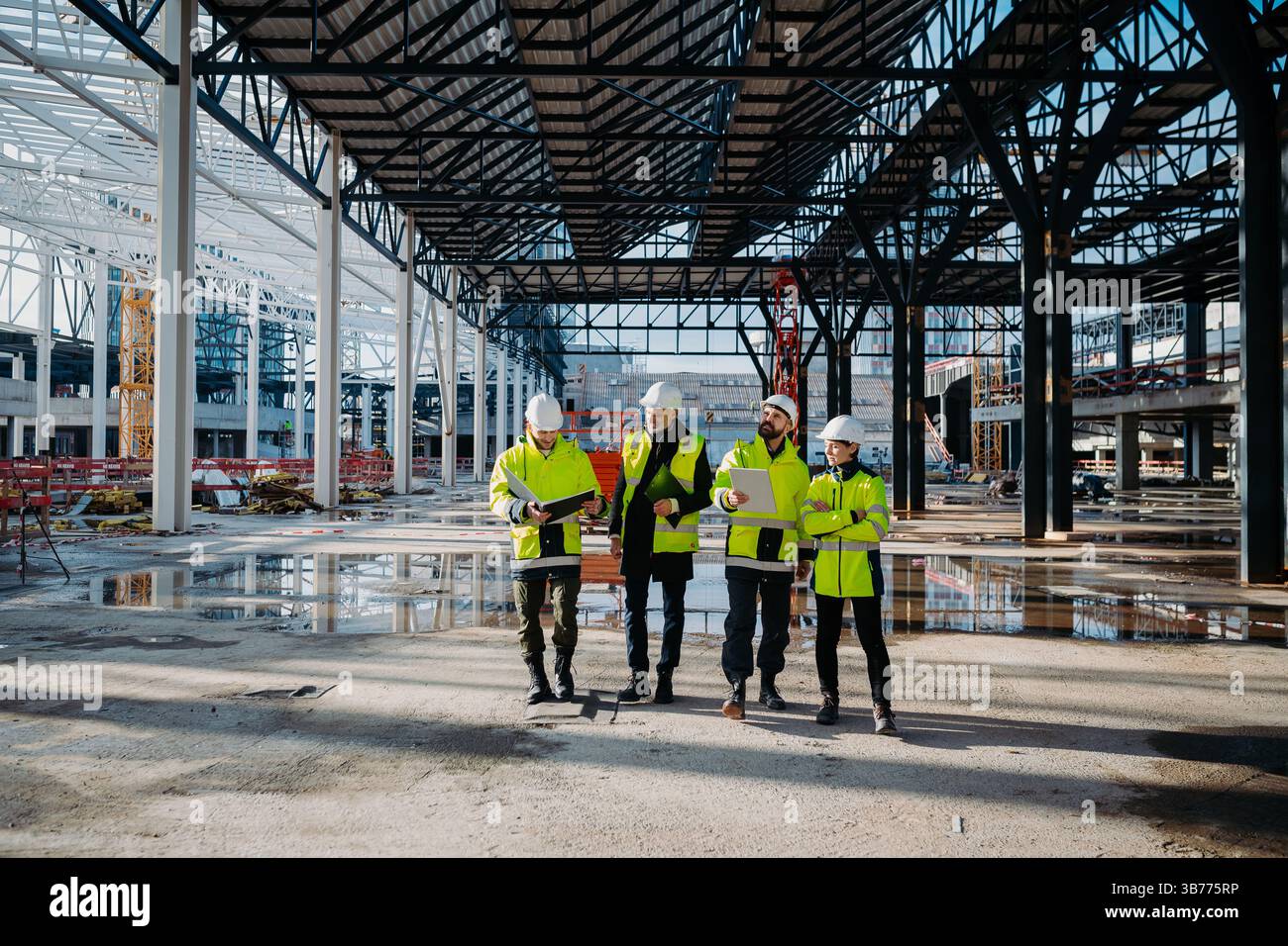 Team of engineers and construction workers inspecting building progress. Stock Photo