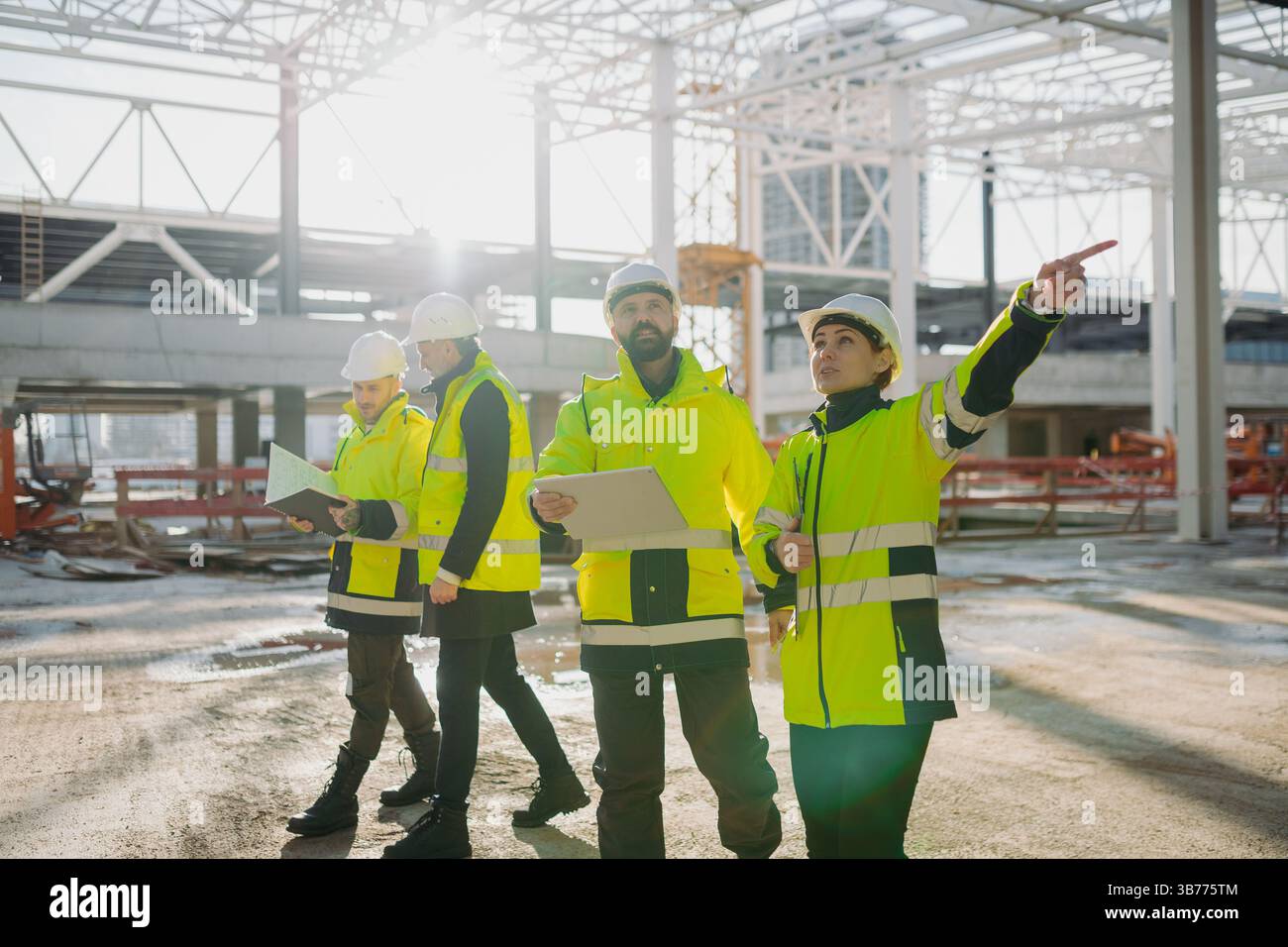 Team of engineers and construction workers inspecting building progress ...