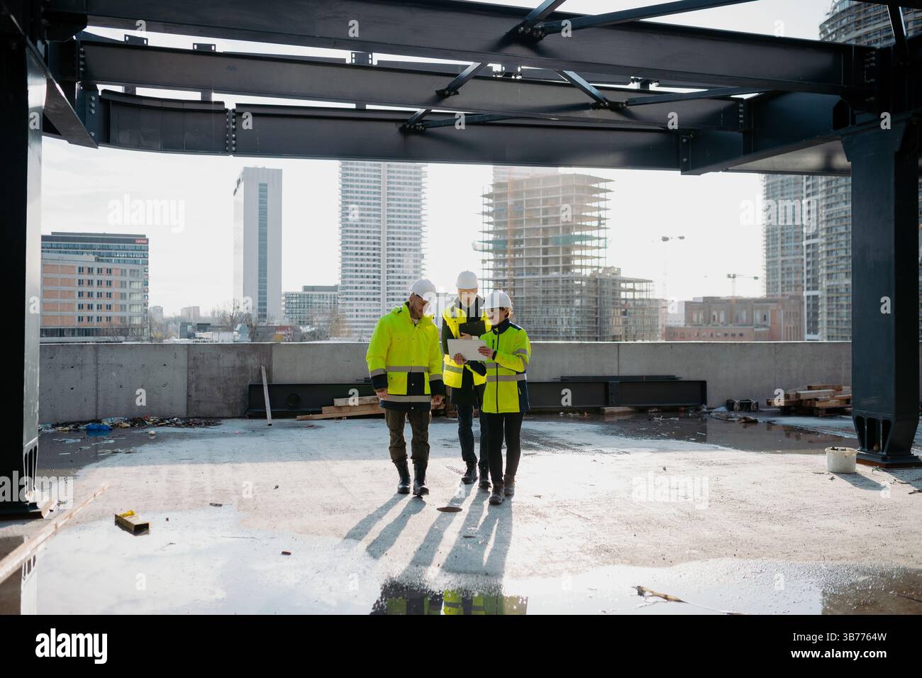 Team of engineers and construction workers inspecting building progress. Stock Photo