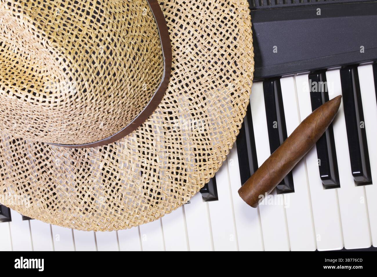 Detail of piano keyboard, straw hat and luxury cigar Stock Photo - Alamy
