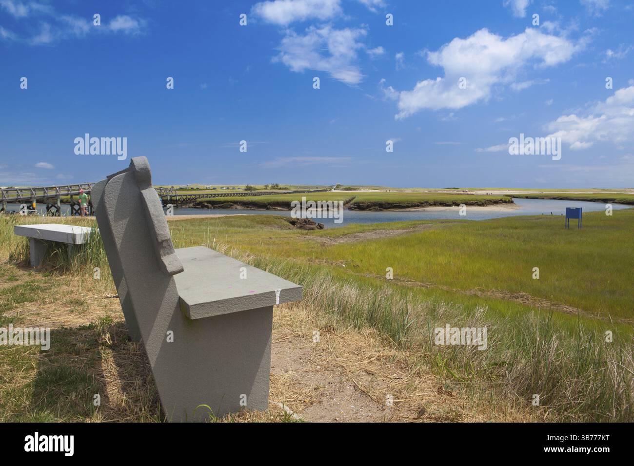 Assachu Concrete bench near the walkway to the dunes. Wooden walkway extends ...