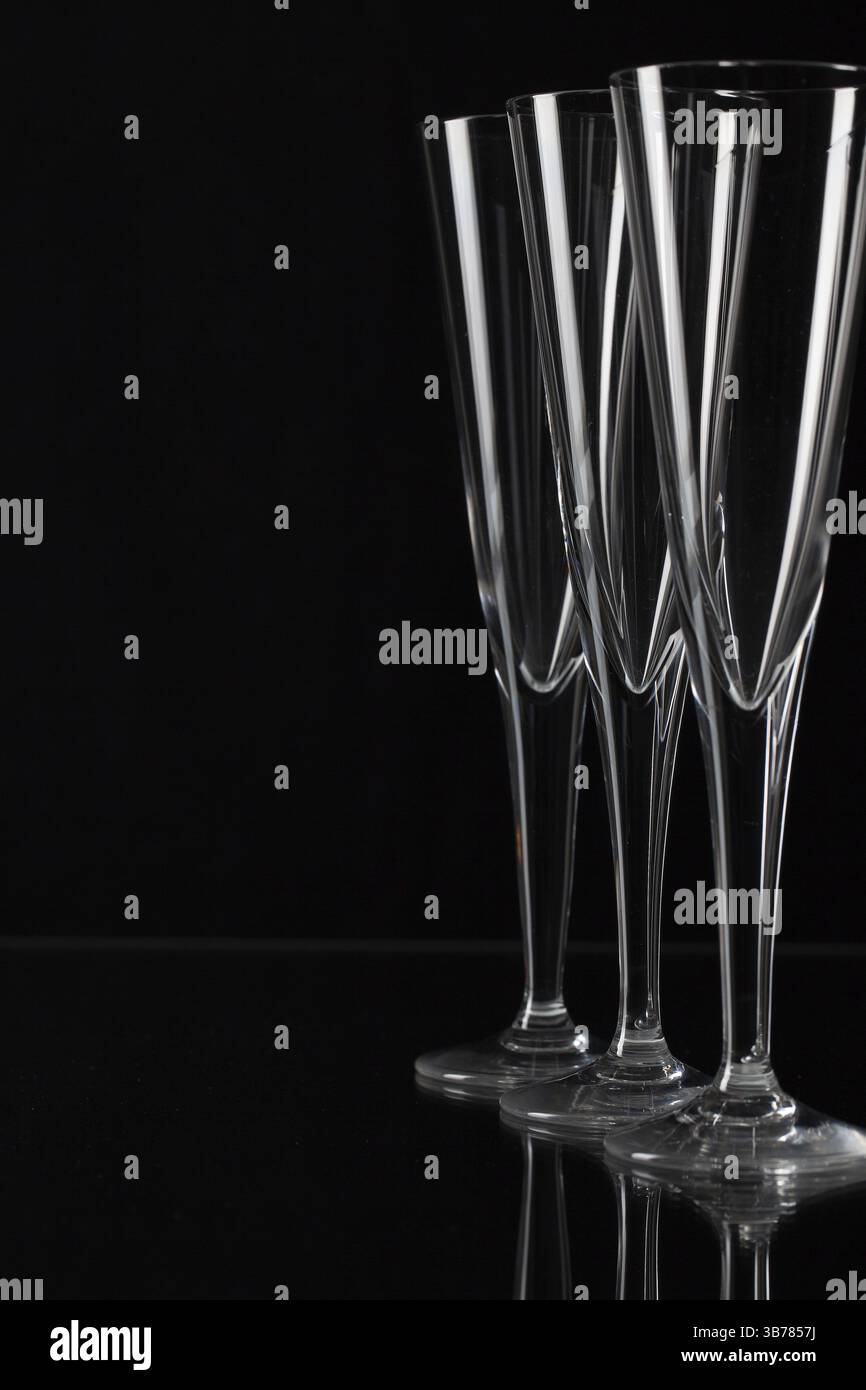 Three empty champagne glasses on a glass plate Stock Photo