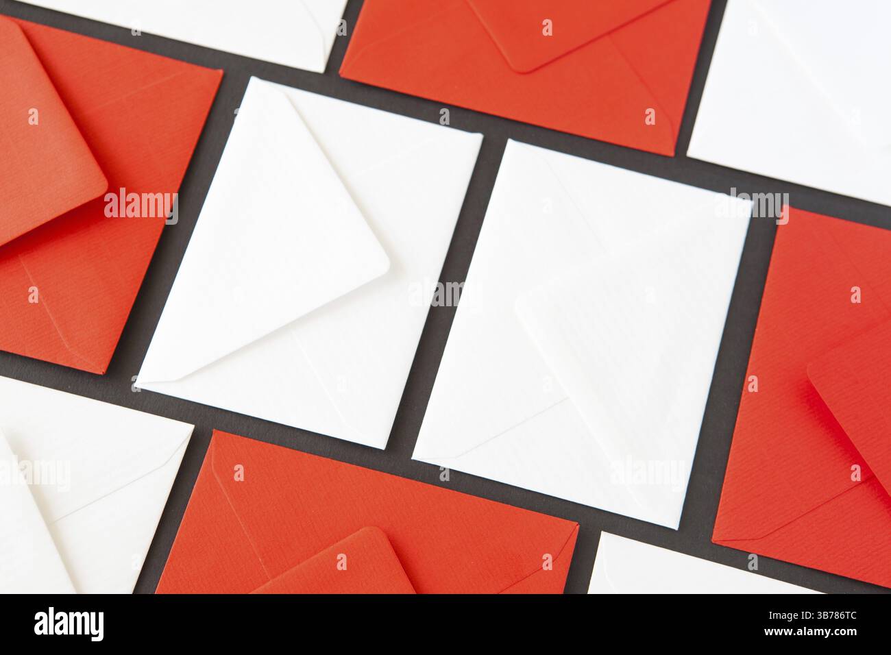 Composition with white and red envelopes on the table. Different colored envelopes on the table Stock Photo