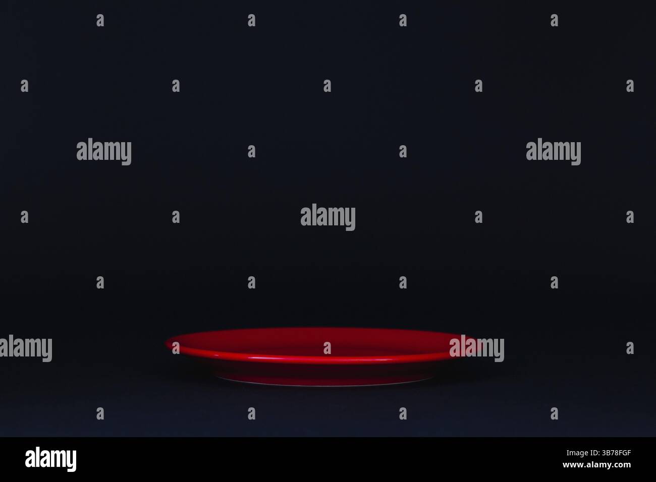 Empty red plate on the black background Stock Photo