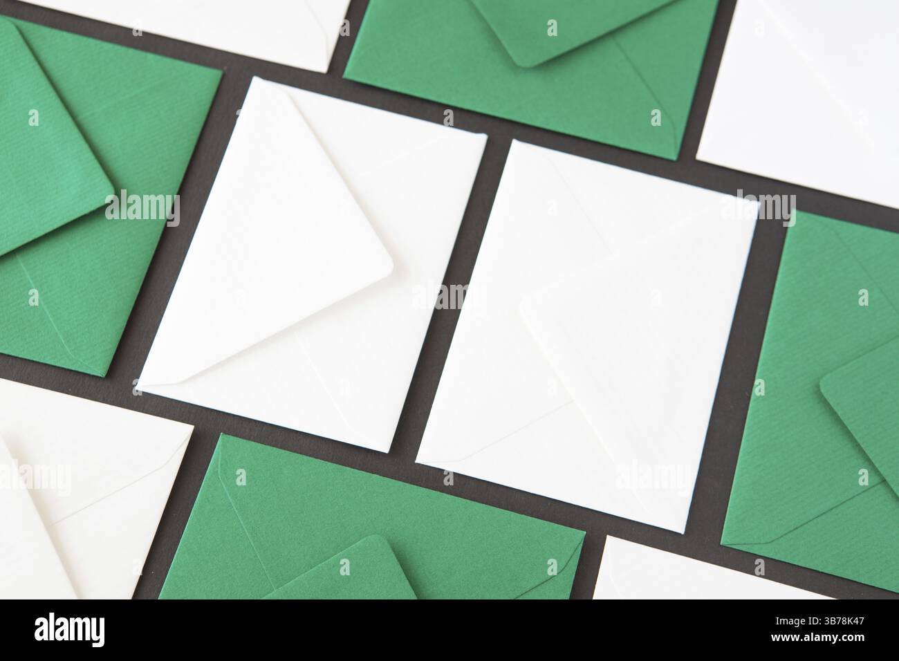 Composition with white and green envelopes on the table. Different colored envelopes on the table Stock Photo