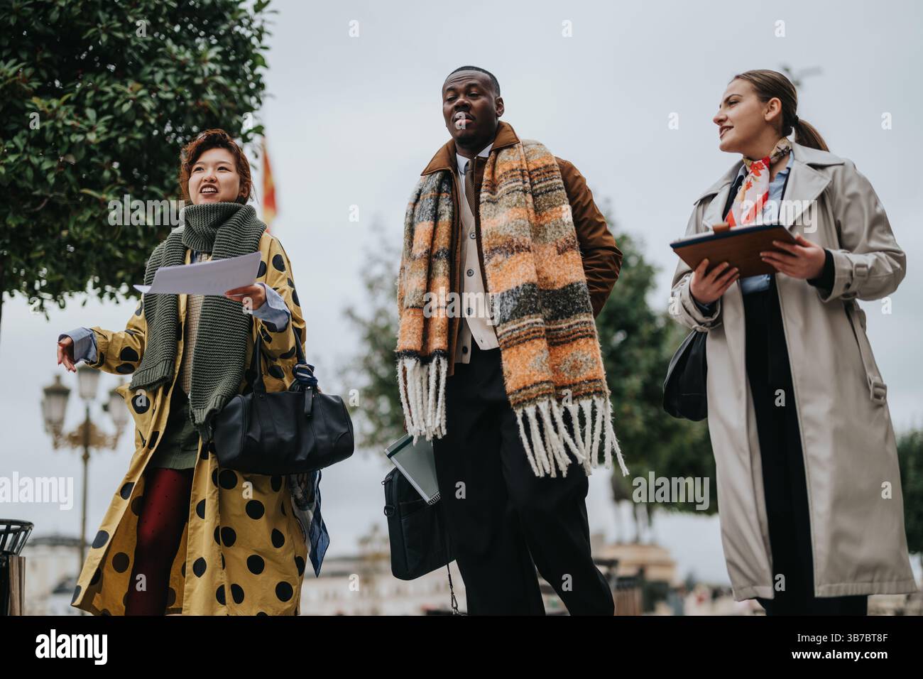 Diverse people walking outdoors engaging in teamwork and discussions Stock Photo