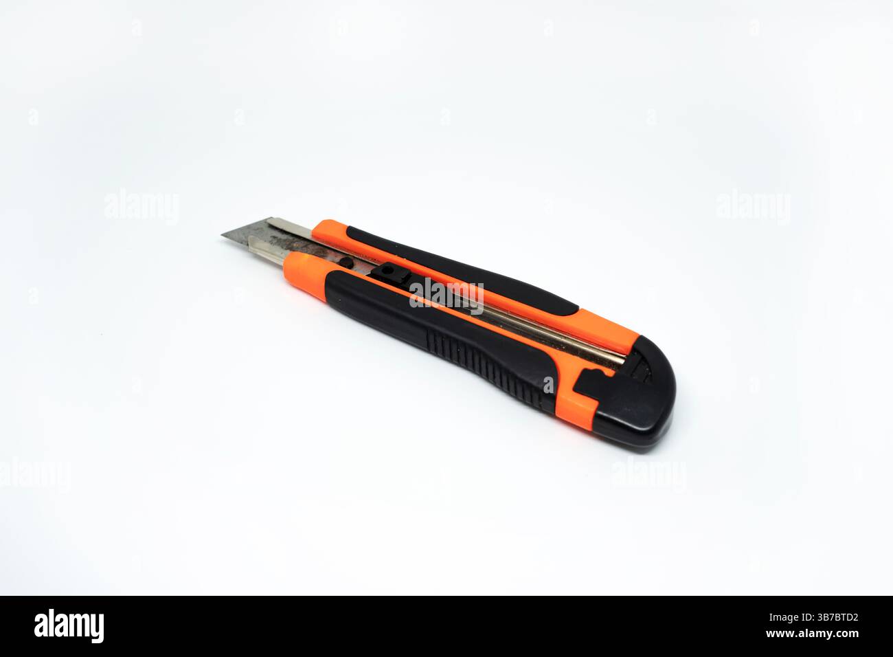 Closeup view of orange cardboard cutter isolated on white background. Box cutter isolated Stock Photo