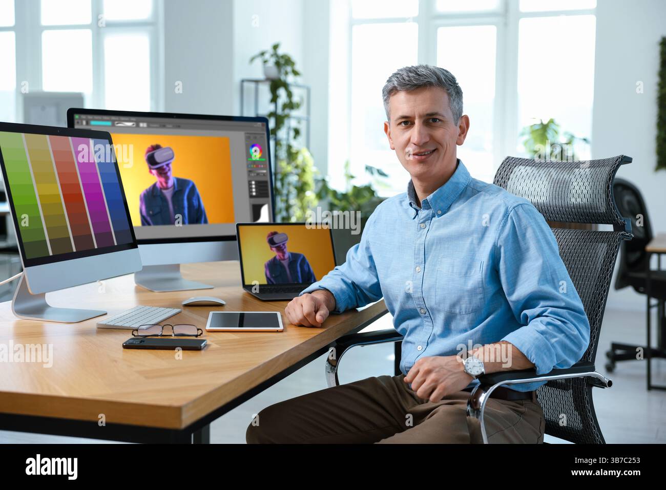 Designer working on different computers at table in office Stock Photo