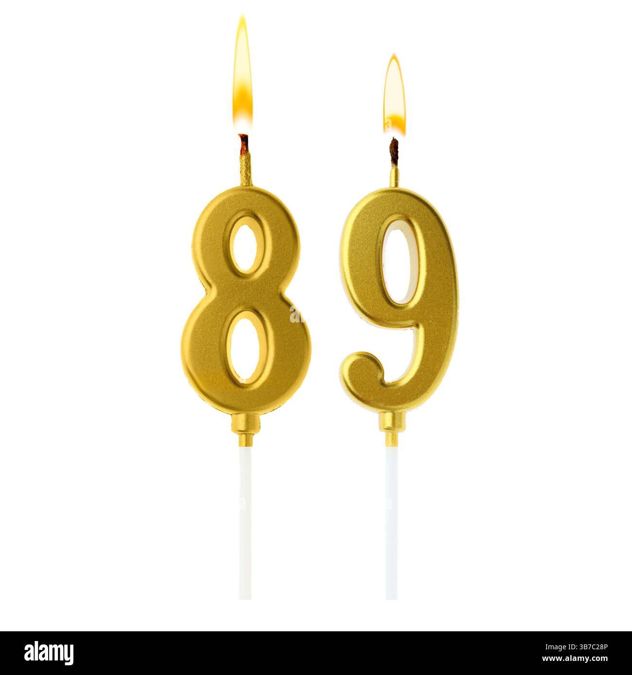 Burning golden cake candles composing number 89 on white background. Festive decoration for birthday or other special date Stock Photo