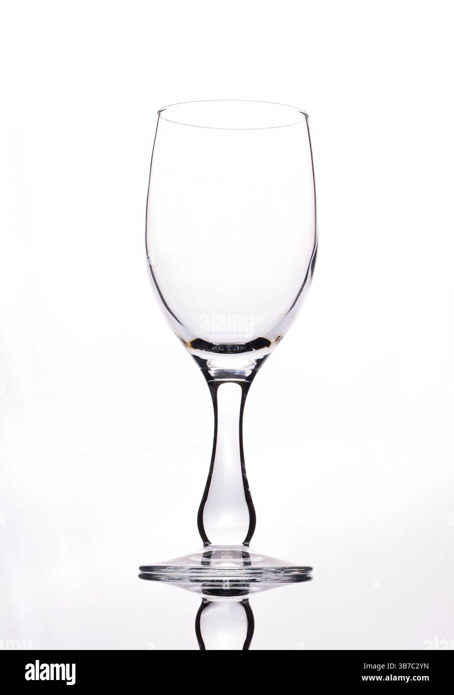 An empty wine glass outlined against a plain white background Stock Photo