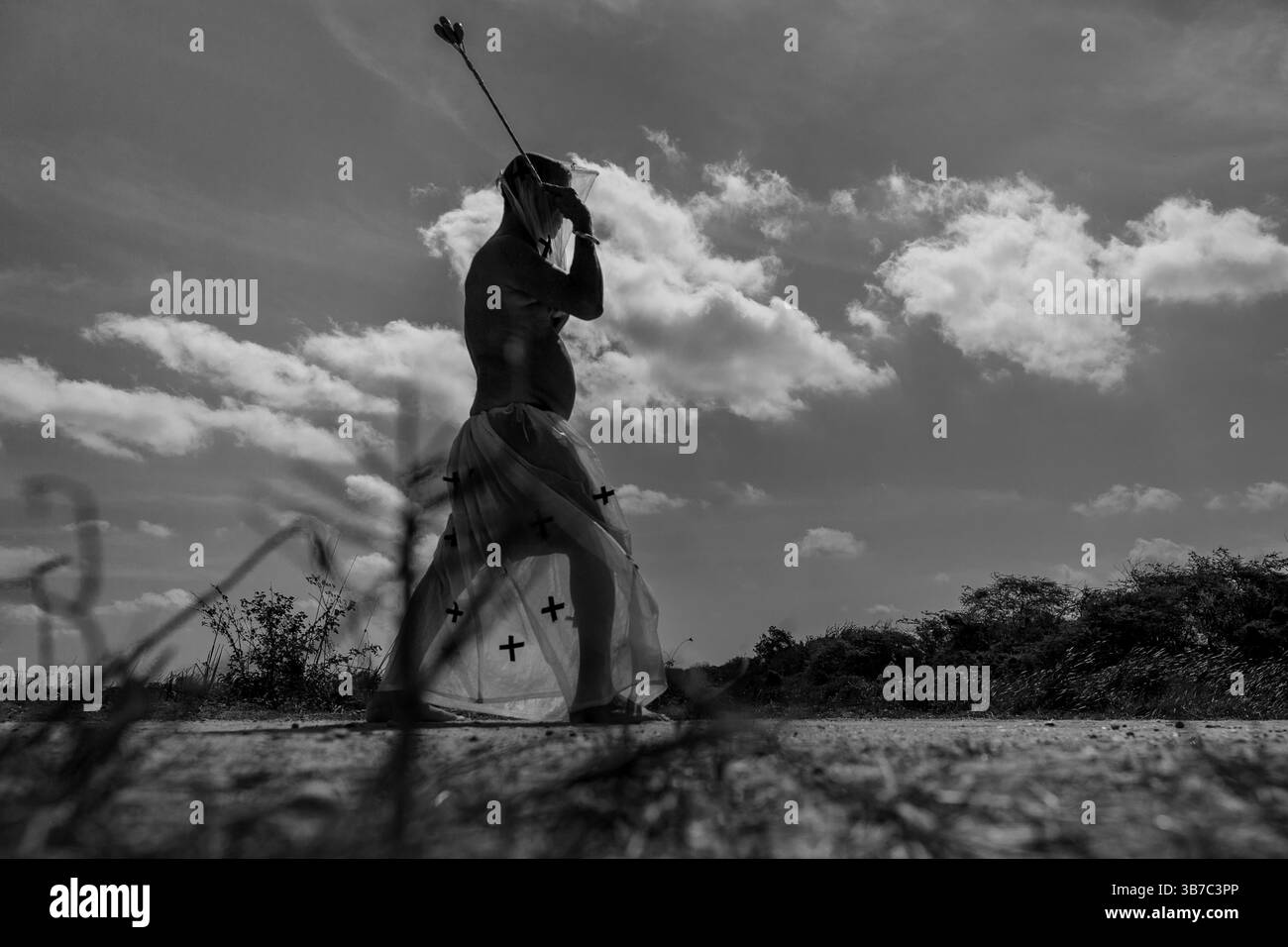An Afro-Colombian man walks while whipping himself as part of a penance ritual during the Holy Week procession in Santo Tomás, Colombia. Stock Photo