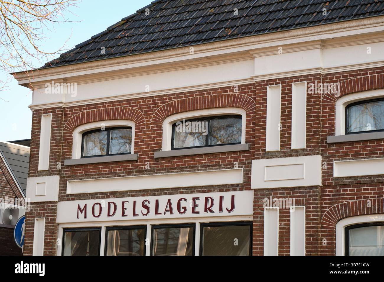 March 4, 2025 - Wirdum-Netherlands: The facade of a historic butcher store with pre-war modern lettering, red brick, and classical elements in Frielan Stock Photo