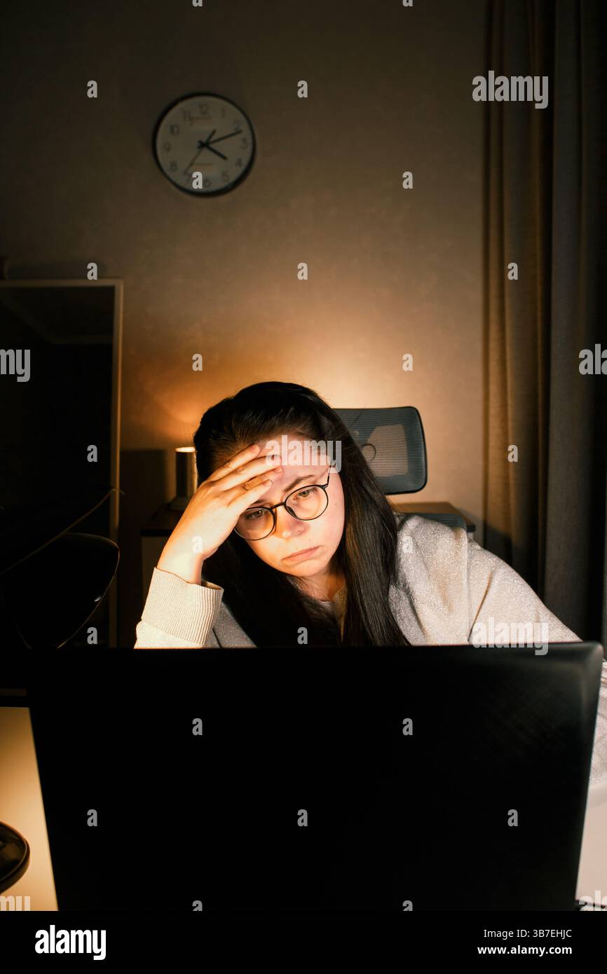 Tired woman working on computer touching her head because of headache ...