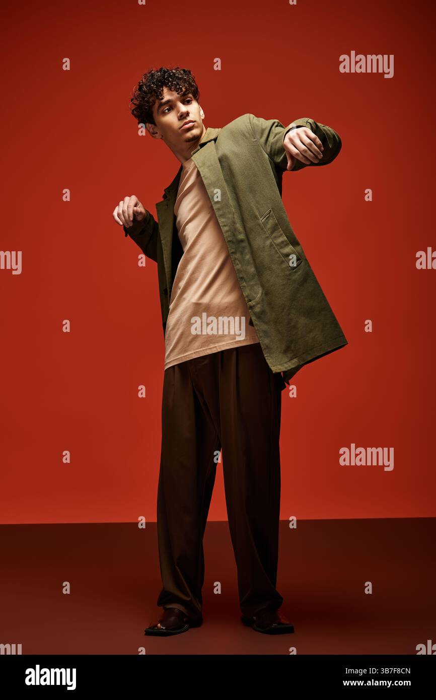 A stylish young man confidently poses against a bold red background in ...