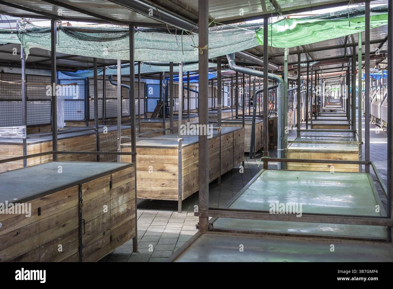Empty covered market with wooden stalls and metal racks Stock Photo - Alamy