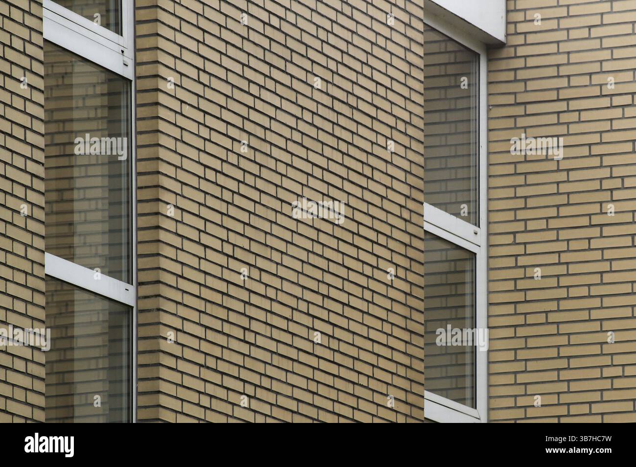 Tan brick wall and windows create a modern and stylish exterior for a ...