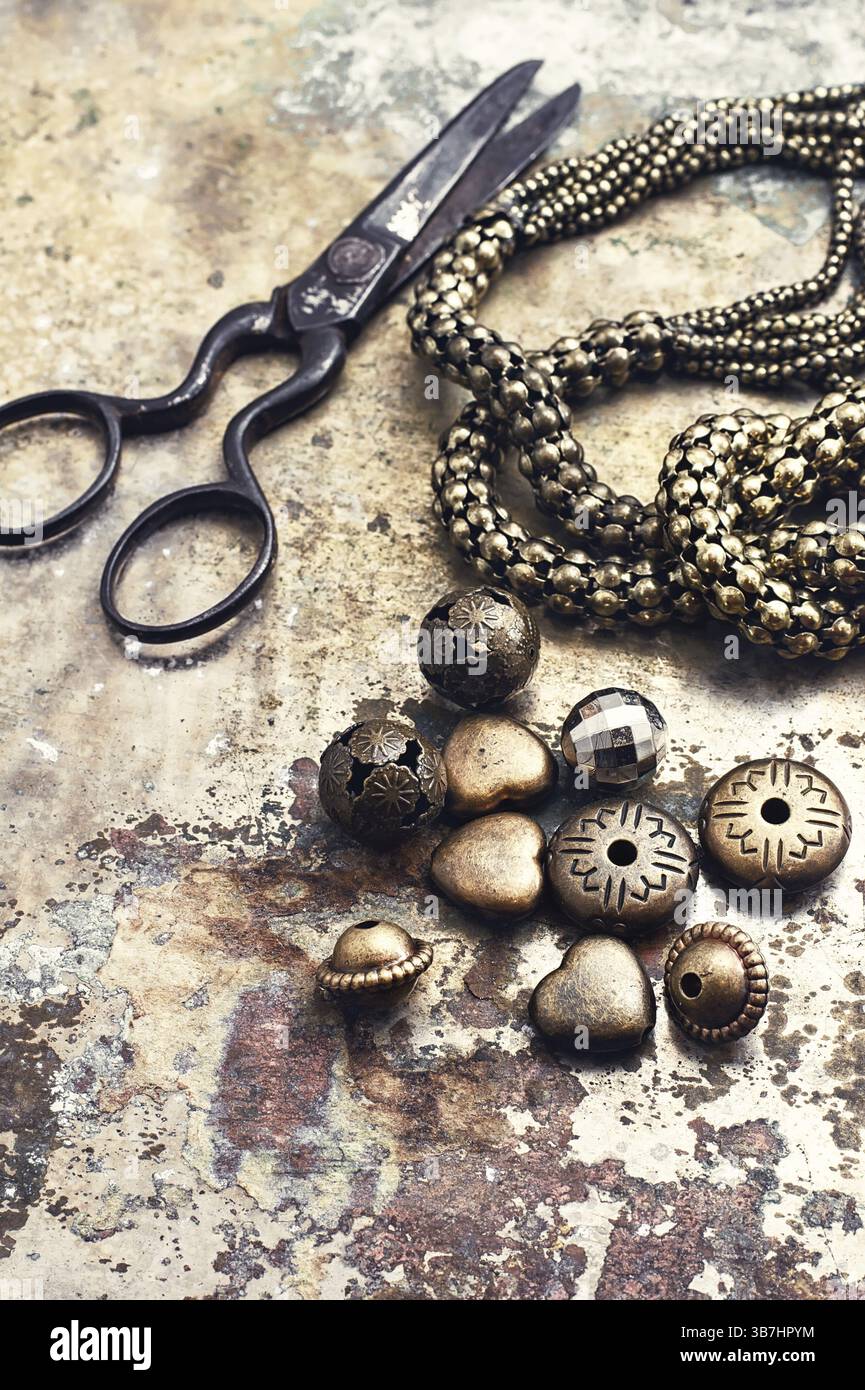 Set of beads and chains for crafts located on metal background Stock Photo
